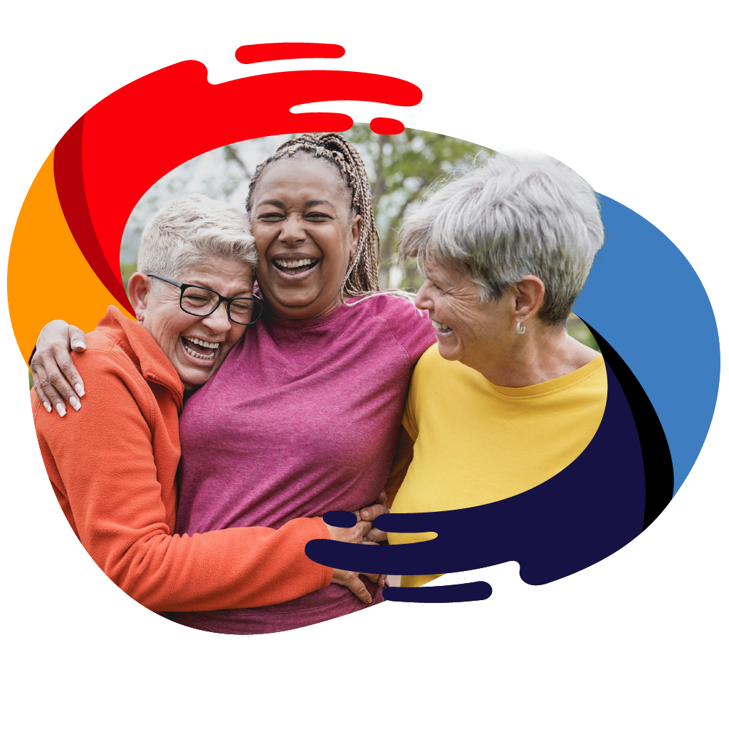 Three older women laughing and hugging